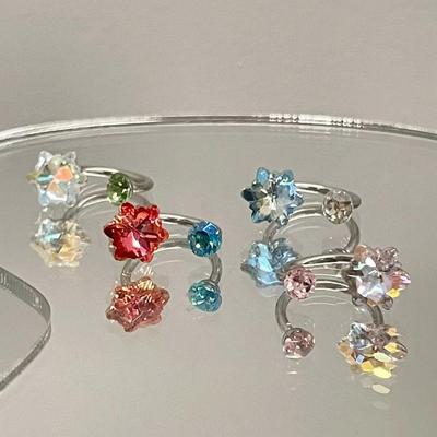 Яркие серьги-снежинки с бриллиантами и эффектное титановое кольцо в форме подковы с U-образными гвоздиками в виде улитки и ушных косточек — милый и стильный стиль.