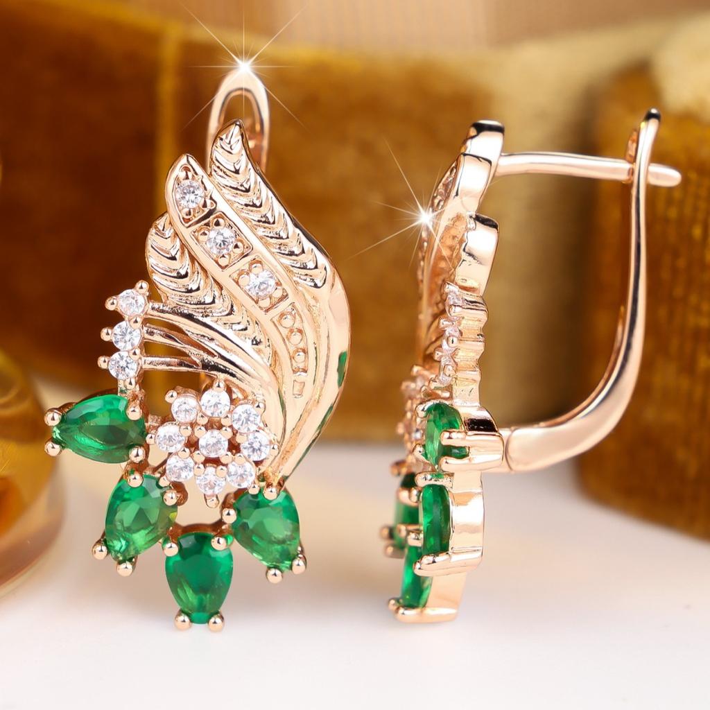 Vintage wing-shaped earrings with ornate carving patterns paired with green teardrop inlays, elegant dangling jewelry suitable for weddings,