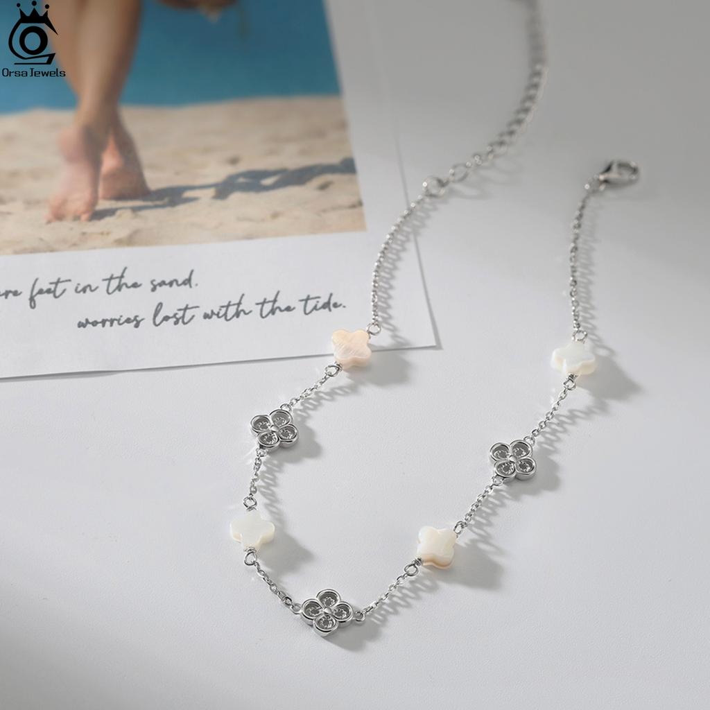 ORSA JEWELS Серебряный браслет на щиколотку 925 пробы с белой ракушкой Дизайн с четырехлистником Стиль природы Счастливый символ Летний аксессуар Подарок GMA03