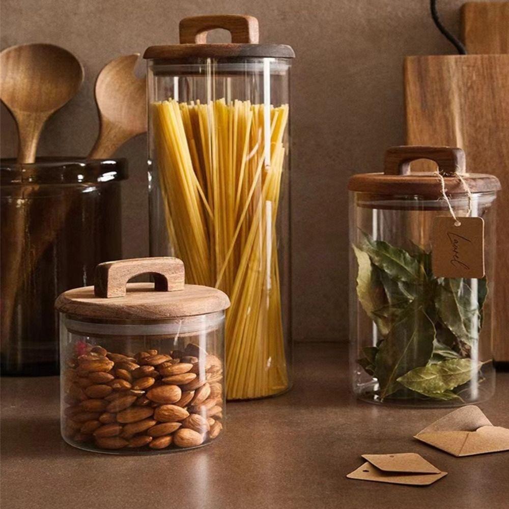Прозрачные стеклянные банки с деревянной ручкой и крышкой. Банка для хранения. Простые герметичные бутылки. Кухня.