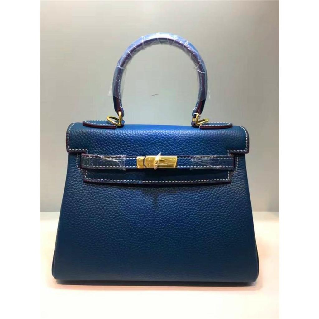 Келли обертывает верхний слой модной сумки-тоут из фактурной коровьей кожи, которую можно носить на плече или через плечо