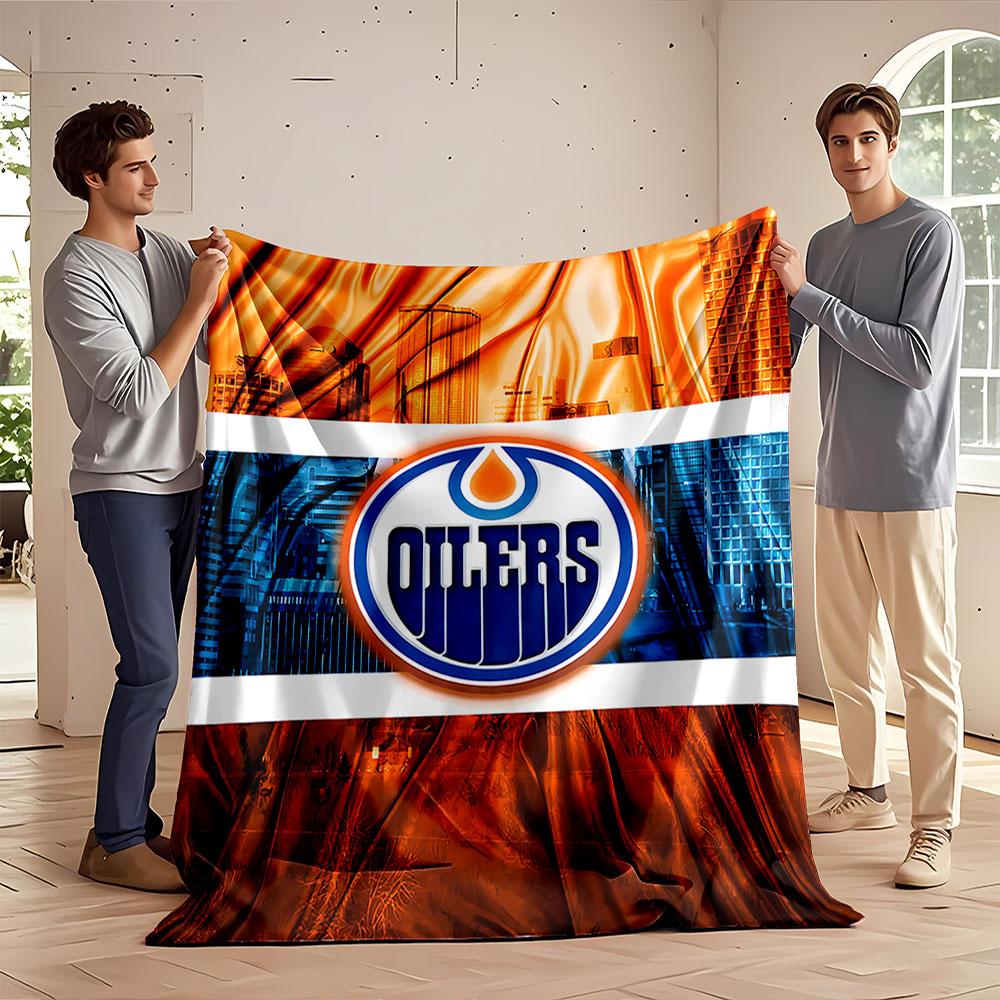 A stylized Oilers logo with orange and blue cityscape and fabric design. for all seasons blanket lunch break throw gift
