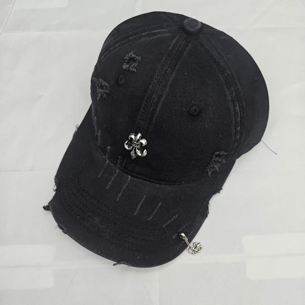 Trendy distressed baseball cap with a small iron badge, duckbill brim, and a paperclip pendant, fashionable for street style and making the face look