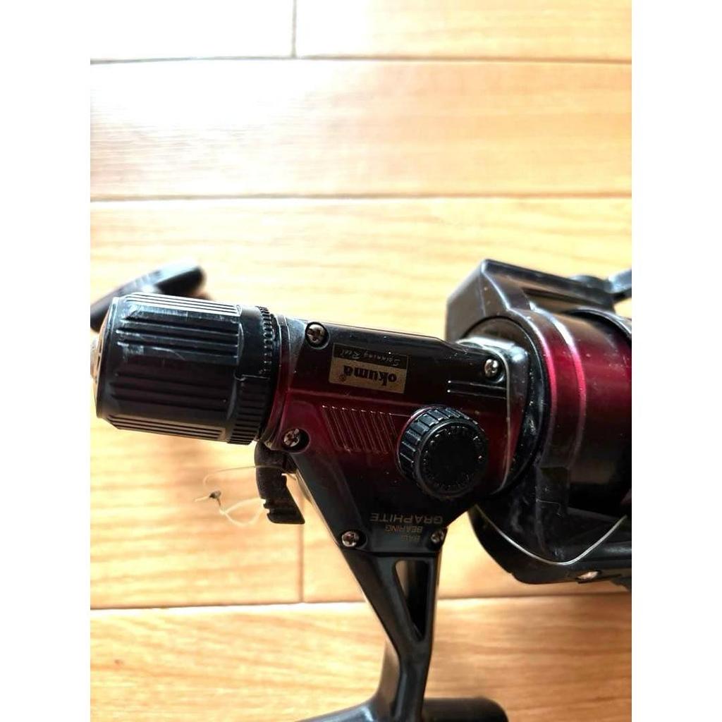 Б/у спиннинговая катушка Okuma GRAPHITE красно-черного цвета, бывшая в употреблении рыболовная катушка