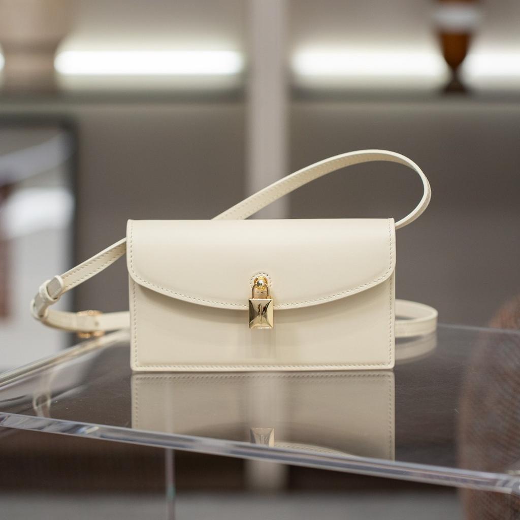 A Small Square Canvas Women's Bag with a Unique Lock and a Light Luxury Style Made of Cowhide