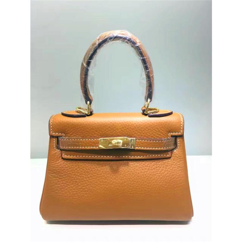 Келли обертывает верхний слой модной сумки-тоут из фактурной коровьей кожи, которую можно носить на плече или через плечо