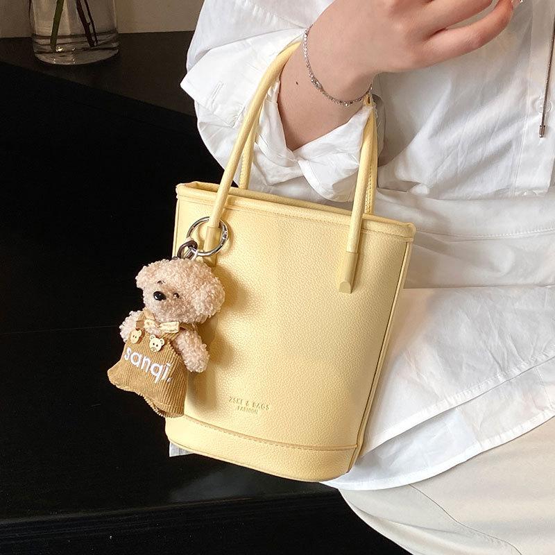 Оптовая продажа новых нишевых простых однотонных сумок-ведер с текстурой «личи», для ношения в руке, универсальных, в зарубежном стиле, для поездок на работу, мессенджеров, женских сумок