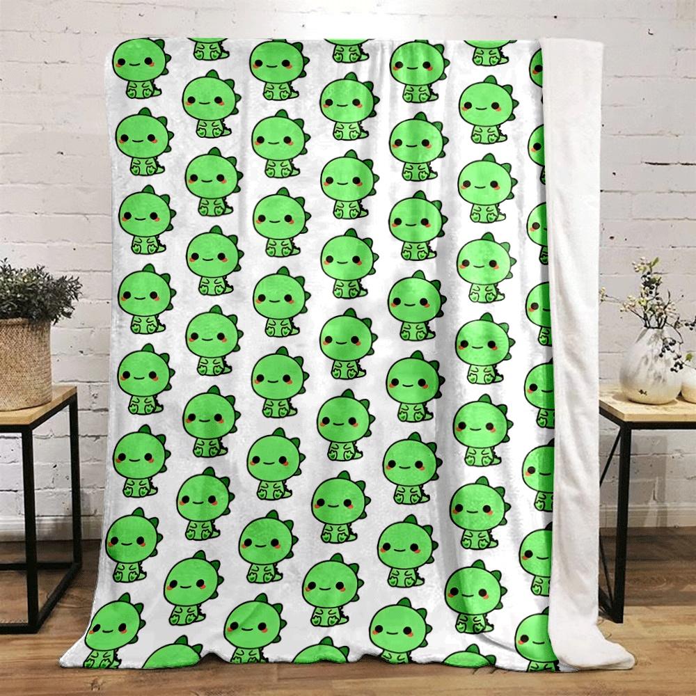 The pattern features rows of small green cartoon dinosaurs with red cheeks. for all seasons blanket lunch break throw gift