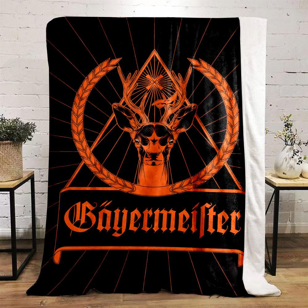 A deer with antlers inside a triangular frame, flanked by grain wreaths. for all seasons blanket lunch break throw gift