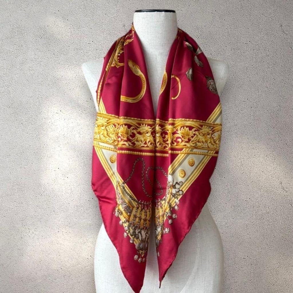 Шелковый платок Trussardi б/у, большого размера, с бирками, золотыми украшениями и ярким узором.