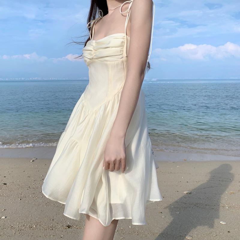 Женские летние нежные платья-бюстье с лямкой на бретельках и бретельками на морском берегу