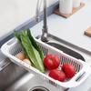 Пластиковый дуршлаг над раковиной с эргономичными ручками для слива и мытья овощей и фруктов