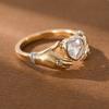 Роскошные руки, держащие кольцо с синтетическим камнем в форме сердца, изготовленное из меди. Женское ювелирное кольцо для банкета.