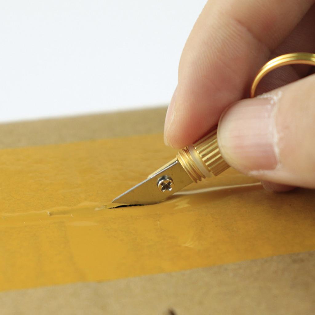 Откройте посылку с небольшим латунным ножом-подвеской, брелком для ключей и портативным капсульным ножом