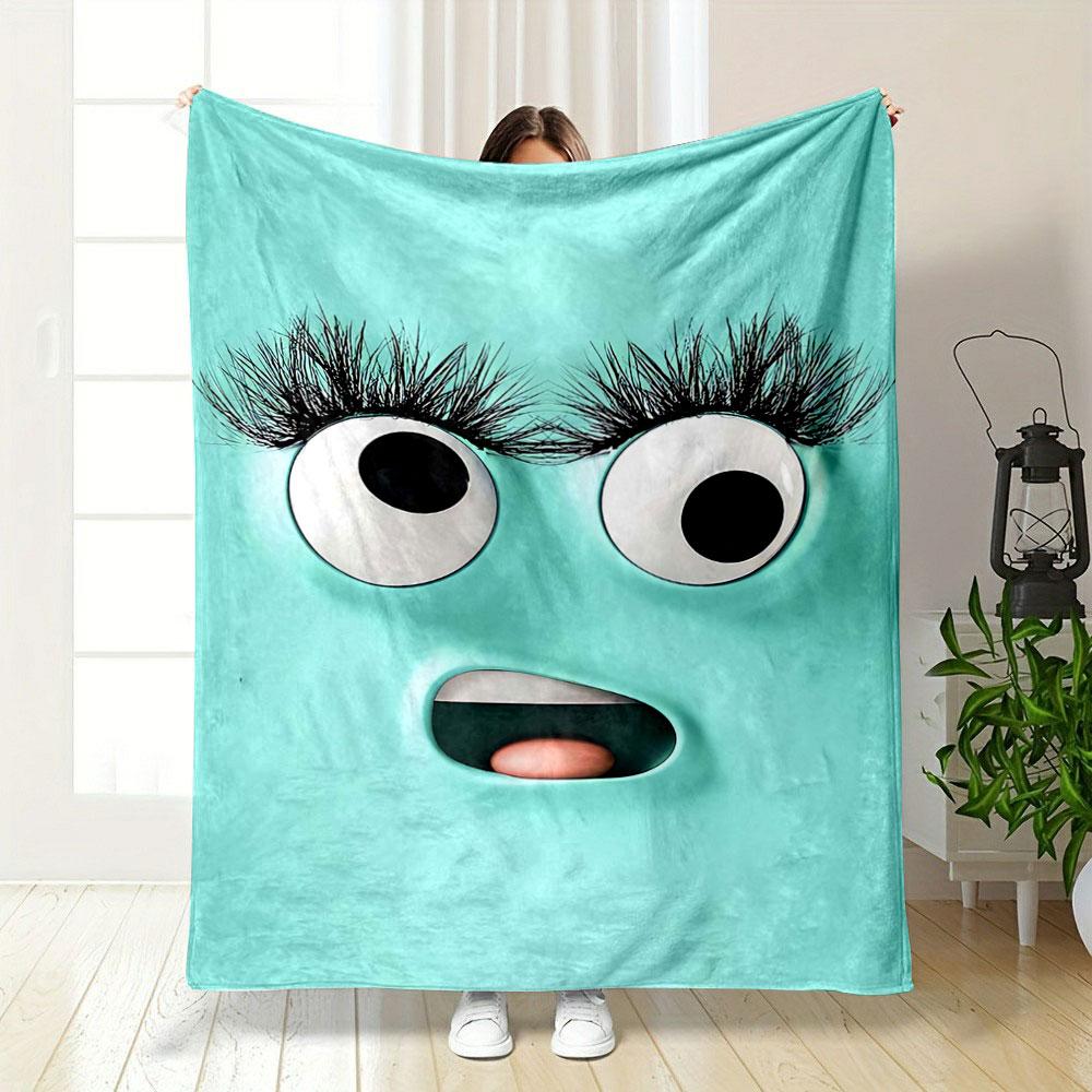 A playful turquoise face with large eyes, long lashes, and an open mouth. for all seasons blanket lunch break throw gift