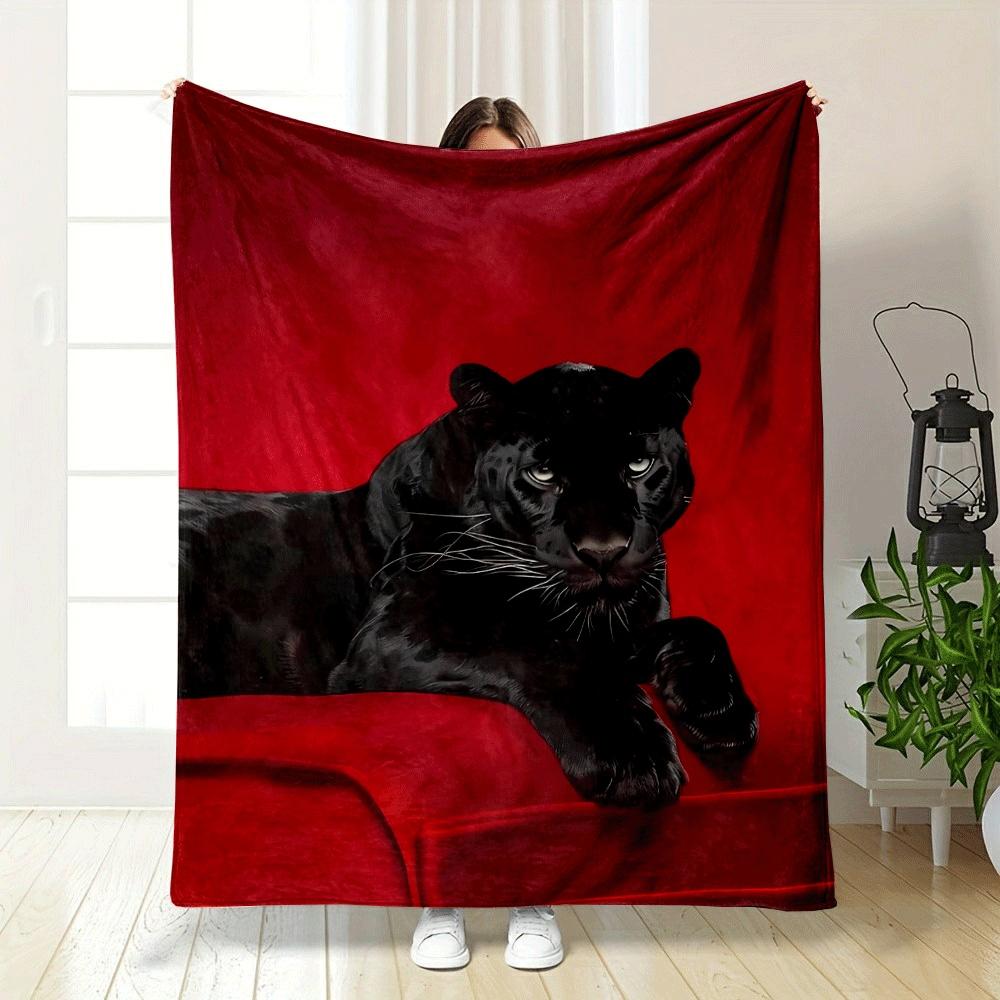 A black panther resting on a vivid red surface with a bold contrast. for all seasons blanket lunch break throw gift