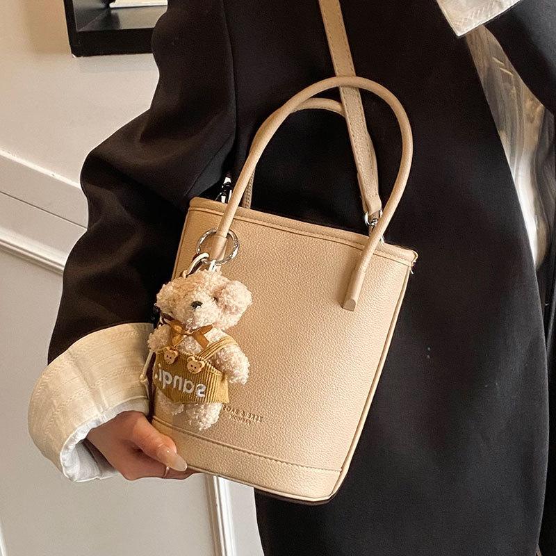 Оптовая продажа новых нишевых простых однотонных сумок-ведер с текстурой «личи», для ношения в руке, универсальных, в зарубежном стиле, для поездок на работу, мессенджеров, женских сумок