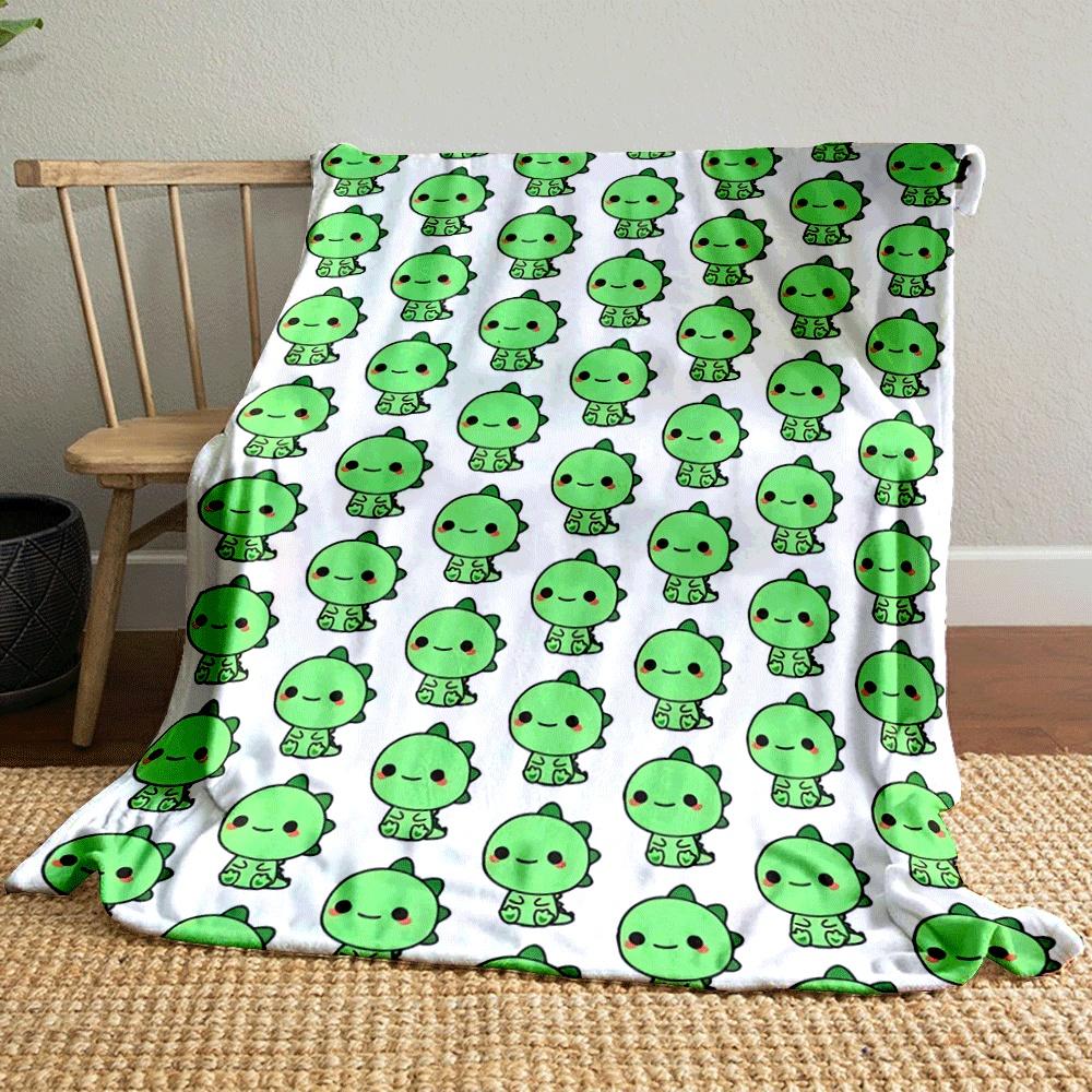 The pattern features rows of small green cartoon dinosaurs with red cheeks. for all seasons blanket lunch break throw gift