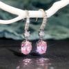 Изогнутые серебряные серьги-крючки, частично усыпанные камнями, с круглыми белыми цирконами, соединенные с овальными имитациями розовых драгоценных камней. Элегантные женские аксессуары для банкета.