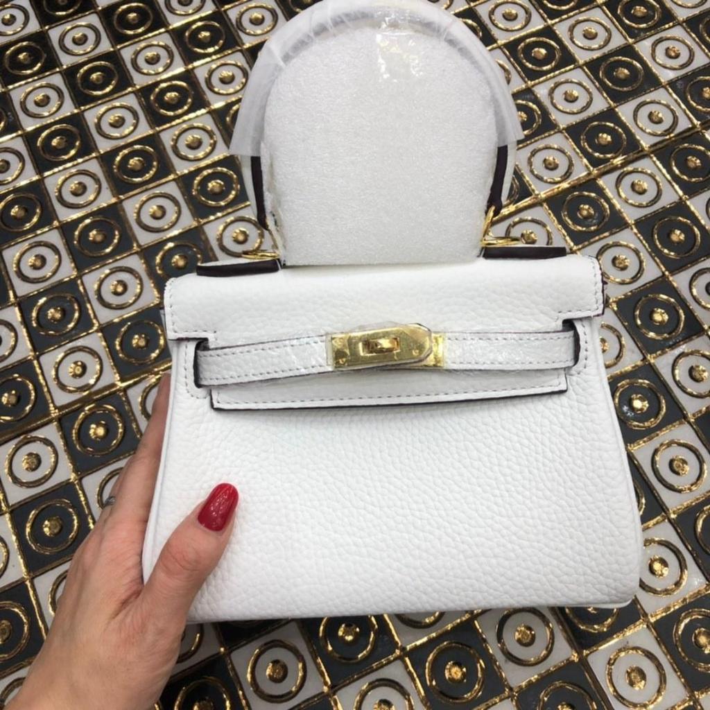 Келли обертывает верхний слой модной сумки-тоут из фактурной коровьей кожи, которую можно носить на плече или через плечо