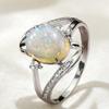 1A silver spiral design women's engagement ring with an oval synthetic opal at the center, accented with synthetic zirconia, is a fashionable