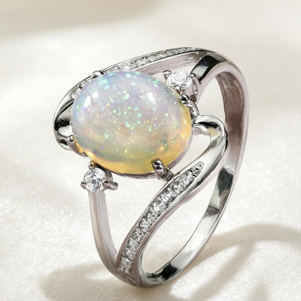 1A silver spiral design women's engagement ring with an oval synthetic opal at the center, accented with synthetic zirconia, is a fashionable