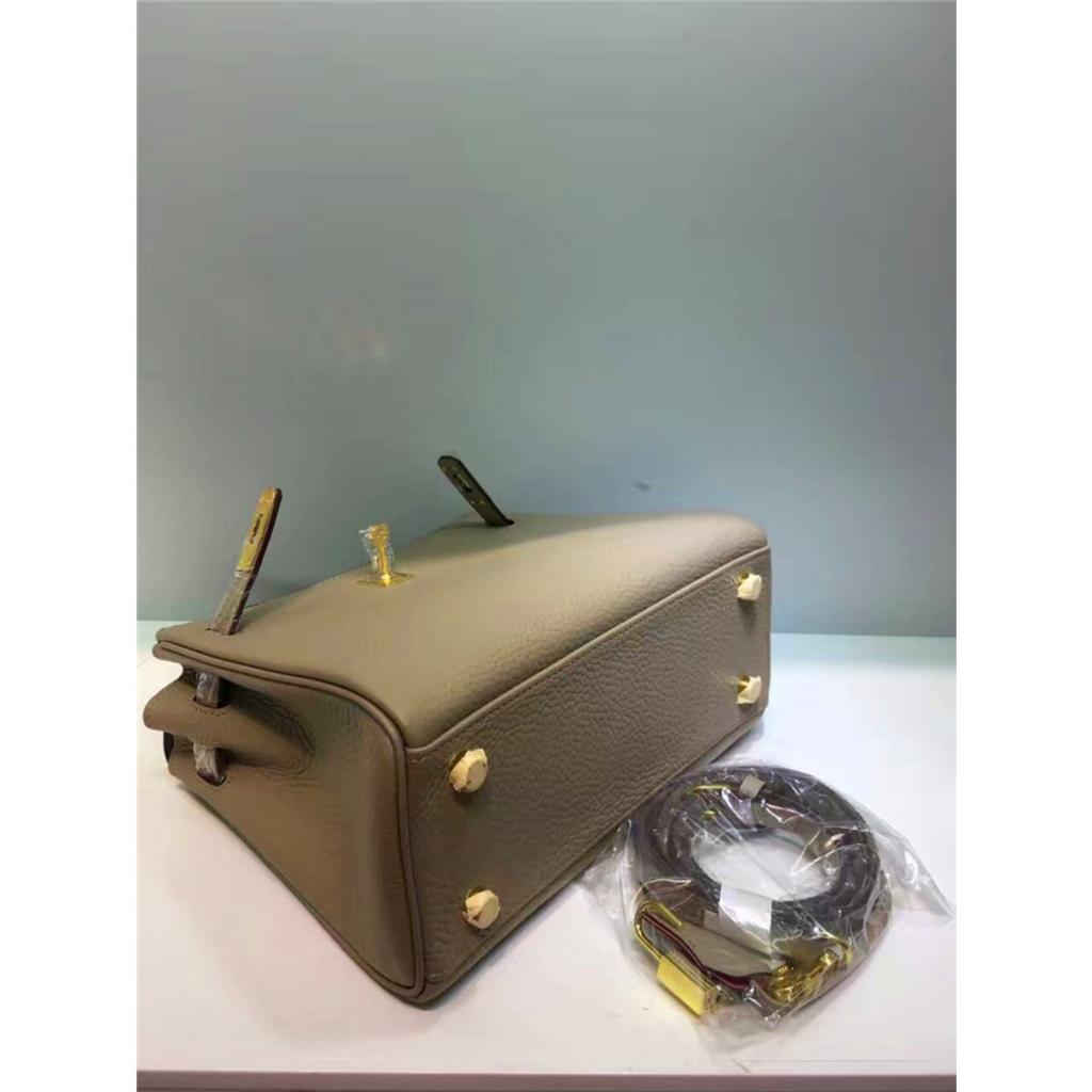 Келли обертывает верхний слой модной сумки-тоут из фактурной коровьей кожи, которую можно носить на плече или через плечо