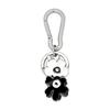 Брелок Marimekko Puhallus Unikko I Kioski (Черное и белое) 093606 910. Этот черно-белый металлический брелок с цветочным логотипом в скандинавском стиле