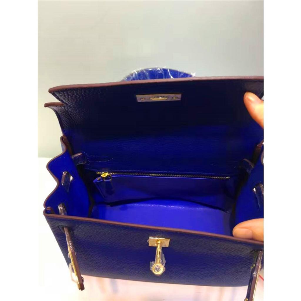 Келли обертывает верхний слой модной сумки-тоут из фактурной коровьей кожи, которую можно носить на плече или через плечо