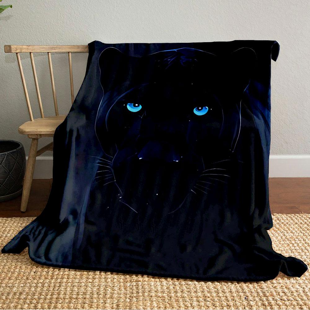 A sleek black panther with glowing blue eyes in a dark background. for all seasons blanket lunch break throw gift