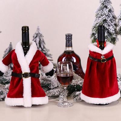 Рождественский обеденный стол с красным вином и модными рождественскими крышками для бутылок вина.
