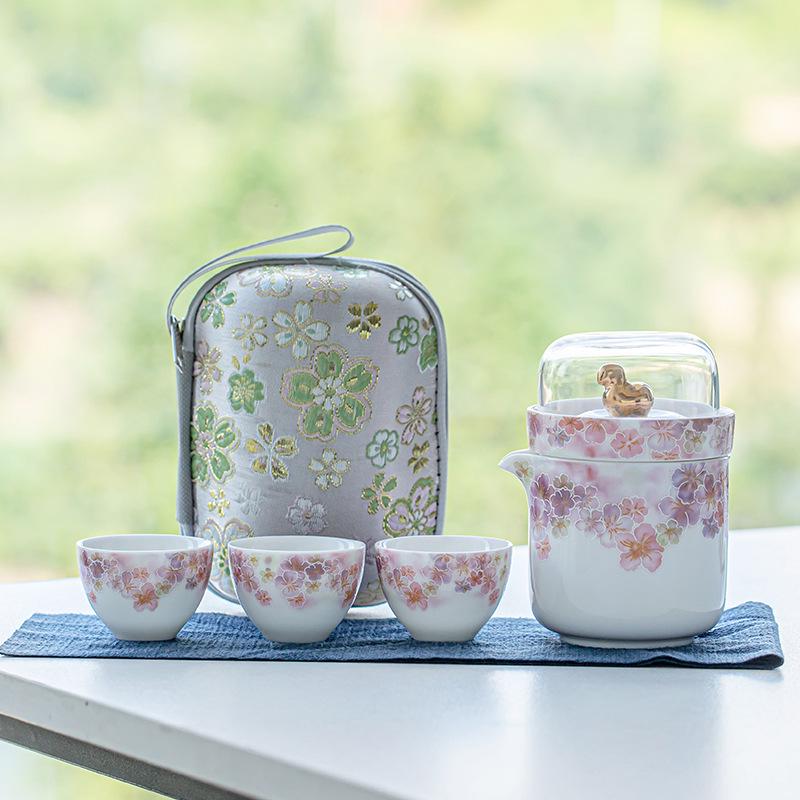 White Porcelain Floral Travel Tea Set: Includes One Pot, Three Cups, and Portable Bag.