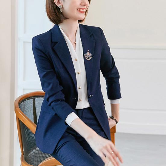 женщина в современном деловом костюме с украшением-павлином