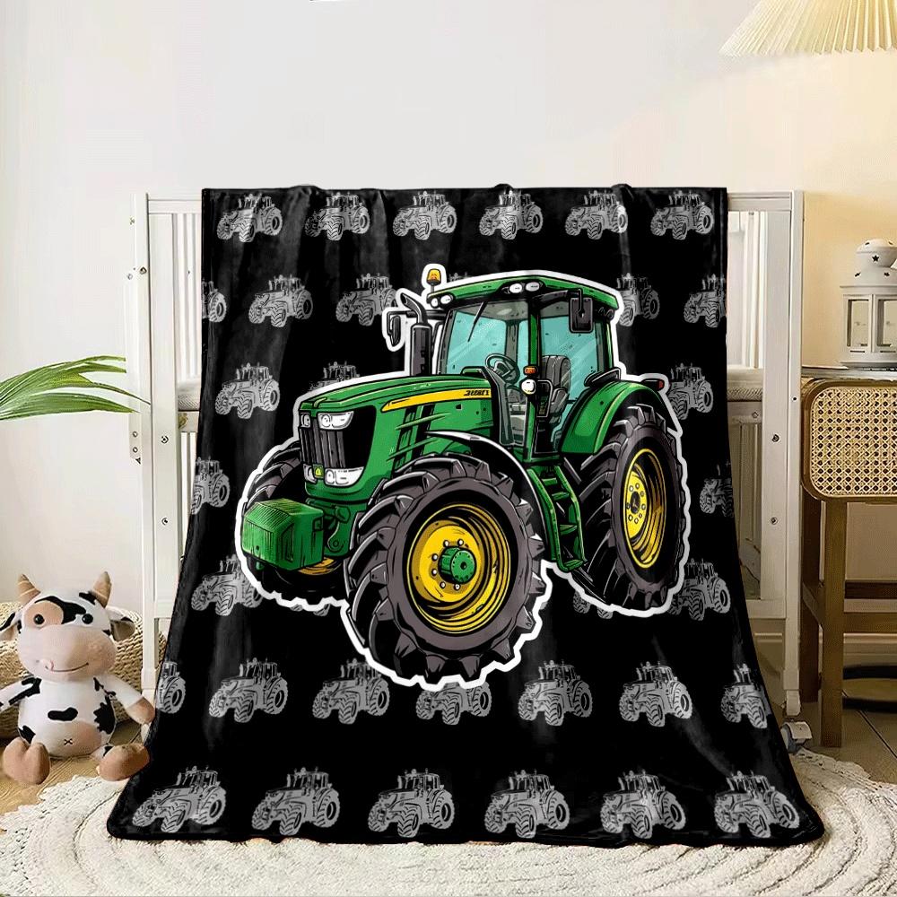 Green tractor artwork on a black background with smaller grey tractors. for all seasons blanket lunch break throw gift