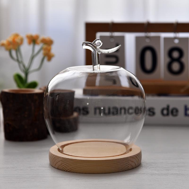 Купол из стекла с изображением вареных яблок и цветов, украшенный глиняной поделкой, для украшения рождественского стола.