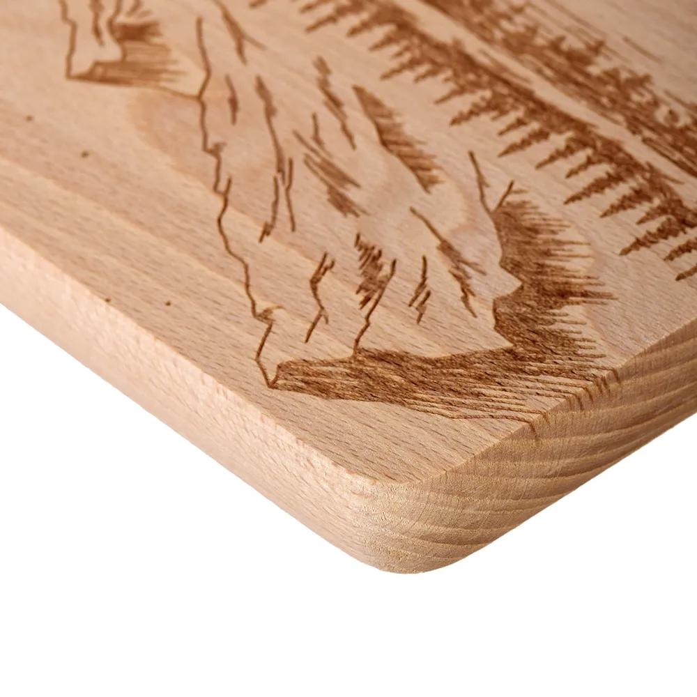 Wooden chopping board with engraved boat and mountains