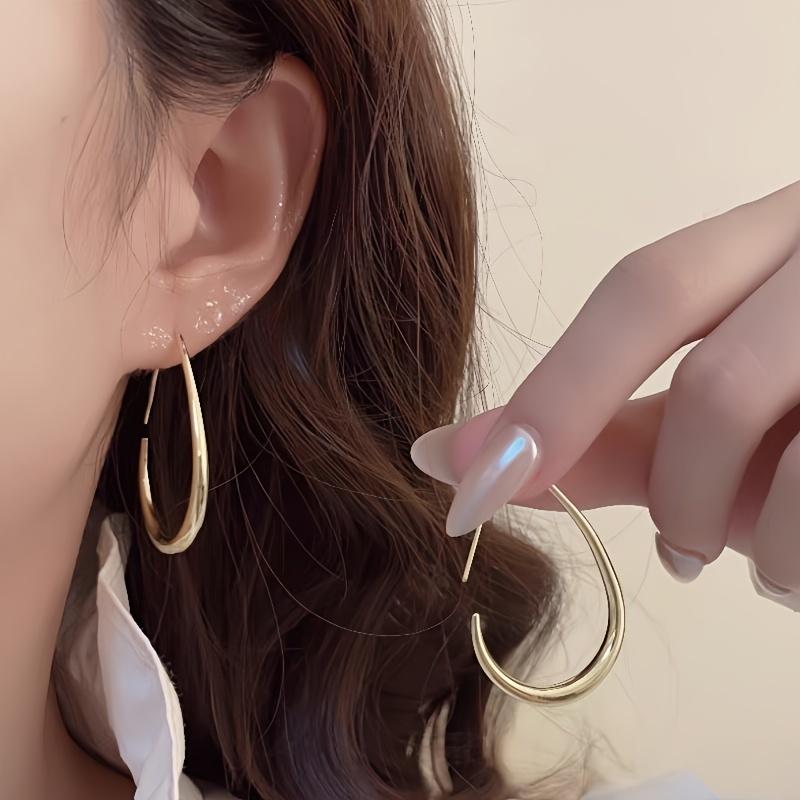 A Pair Of Minimalist Chic Teardrop-shaped Hoop Earrings, Exuding Elegance, Perfect For Ladies To Wear To Parties And Vacations.