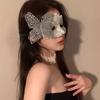 Cosmetic masquerade party with a sexy half-face makeup woman wearing a half-face erotic lace mask, a Halloween feather mask