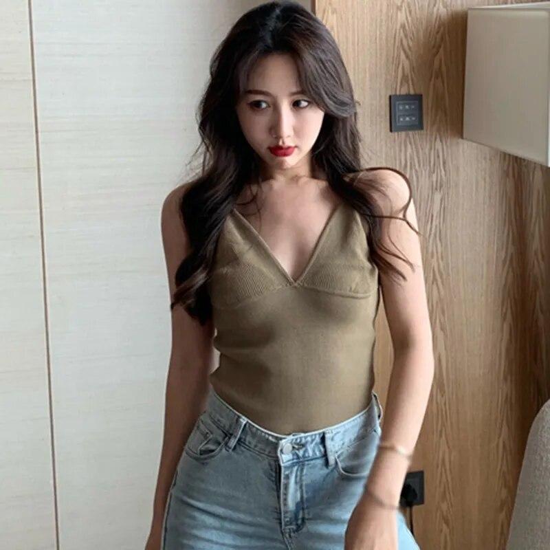 Подтяжки с глубоким V-образным вырезом и низким вырезом. Маленький жилет. Женщины носят топы без рукавов.