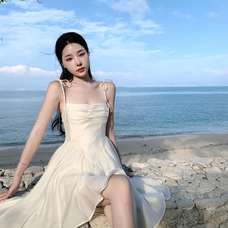 Женские летние нежные платья-бюстье с лямкой на бретельках и бретельками на морском берегу
