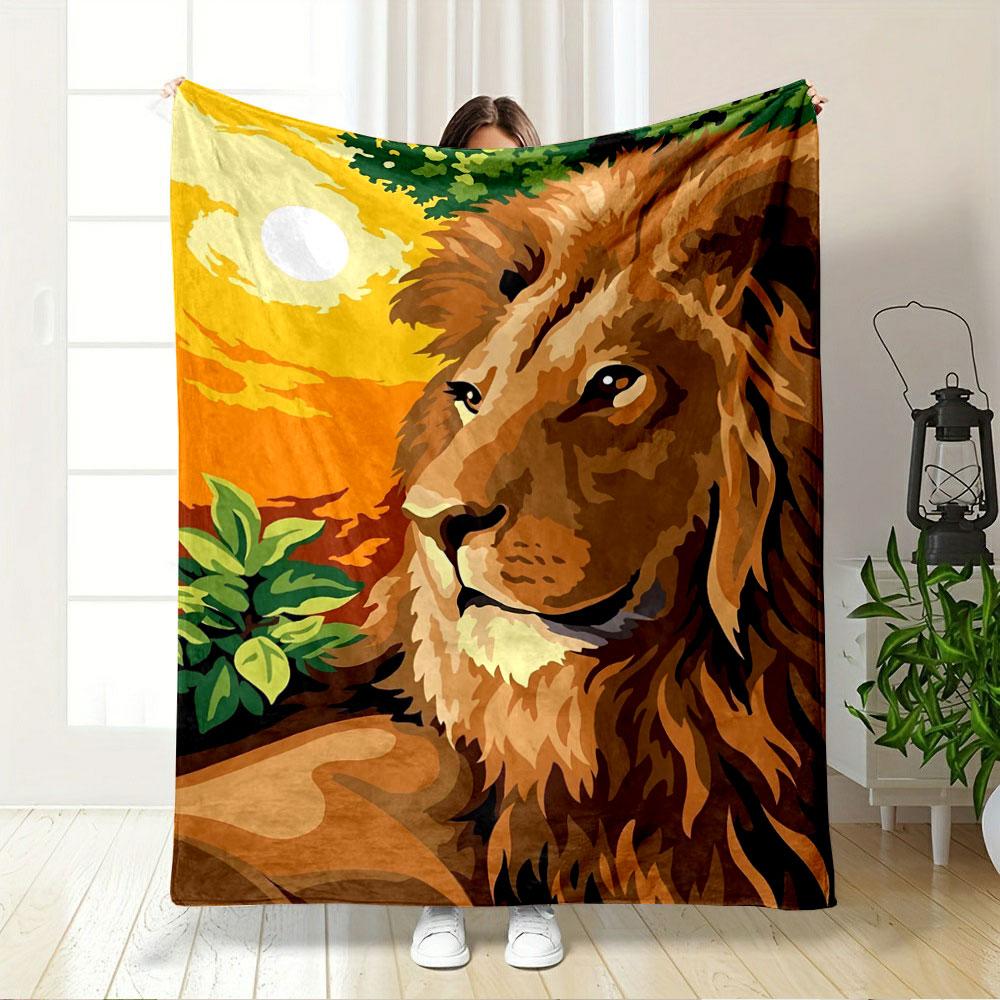 A majestic lion with a vibrant orange sunset and green foliage background. for all seasons blanket lunch break throw gift