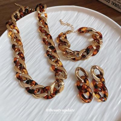 Ювелирный набор с леопардовым принтом Meillard: Серьги-кольца, ожерелье, браслет и серьги-пусеты.