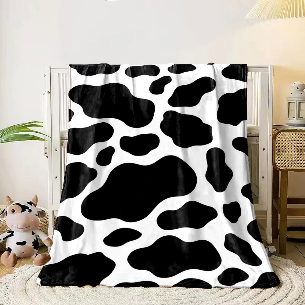 Black irregular spots on a white background resembling a cow print. for all seasons blanket lunch break throw gift