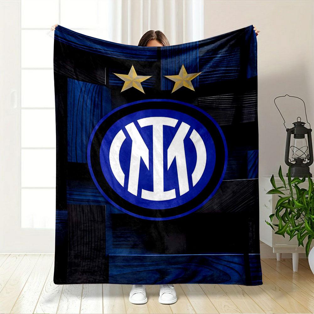 Intertwined white letters in a blue circle, two gold stars above, wood-like background. for all seasons blanket lunch break throw gift