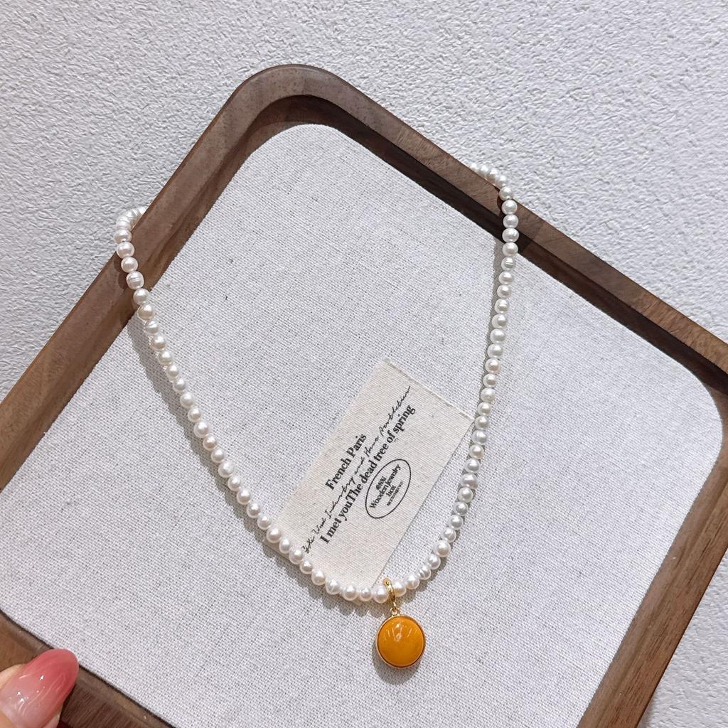Autumn and winter French-style vintage natural pearl clavicle necklace Amber round pendant, a niche and high-end necklace