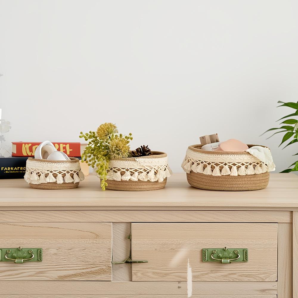 Набор из трех плетеных корзин для хранения вещей с круглыми кисточками и хлопковой веревкой в ​​деревенском стиле.