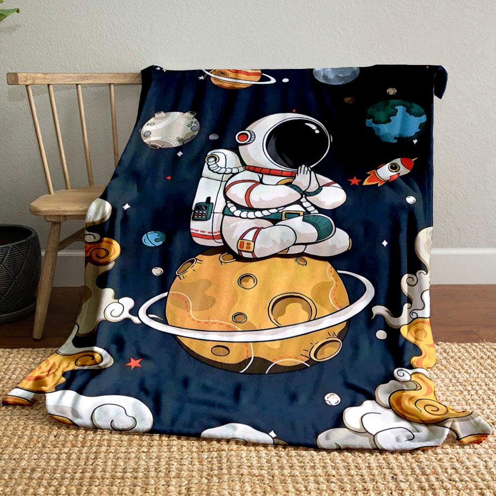 A meditating astronaut sits on a ringed planet amid whimsical space objects. for all seasons blanket lunch break throw gift