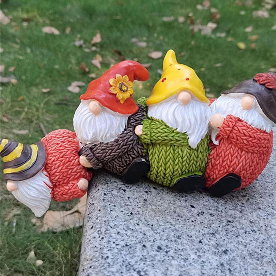 Рождественский гном, сидящий на полке, статуэтка, свисающая с края стола, четыре безликих