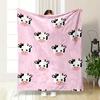 Smiling cow faces with horns and spots are arranged on a pink background. for all seasons blanket lunch break throw gift