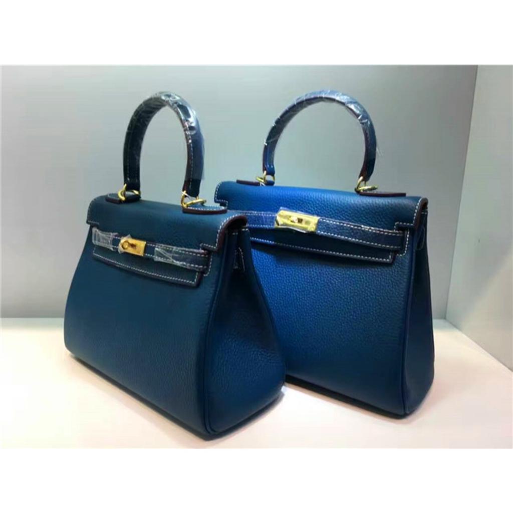 Келли обертывает верхний слой модной сумки-тоут из фактурной коровьей кожи, которую можно носить на плече или через плечо